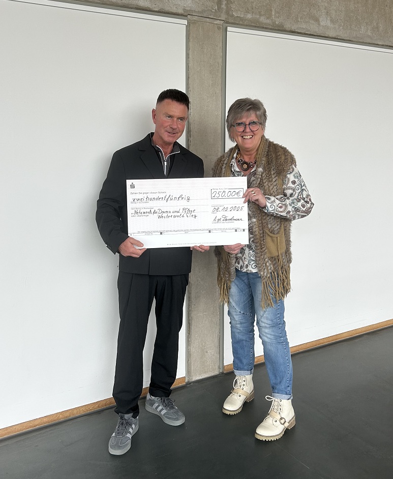 zwei Personen und ein Spendenscheck
